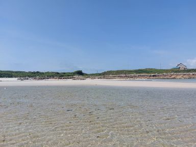 A beach scene with water and a house at Tigh Marie
