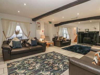 A living room with sofas and a fireplace at Newlands Fell House in Newlands near Keswick