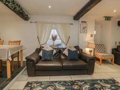 A living room with a sofa and dining table at Newlands Fell House near Keswick