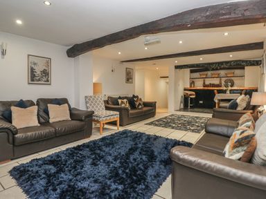 A living room with sofas and a bar at Newlands Fell House near Keswick