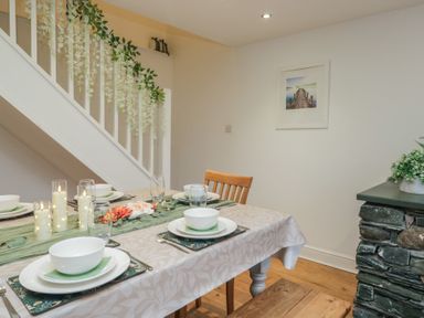 A dining room with a table set for a meal at Newlands Fell House in Newlands near Keswick