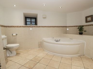 A bathroom with a bathtub and toilet at Newlands Fell House in Newlands near Keswick