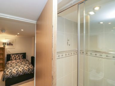 A bedroom with a bed and a shower area at Newlands Fell House in Newlands near Keswick