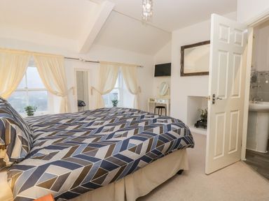 A bedroom with a bed and dressing table at Newlands Fell House near Keswick