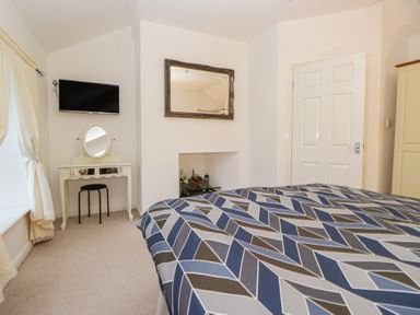 A bedroom with a television and a dressing table at Newlands Fell House near Keswick