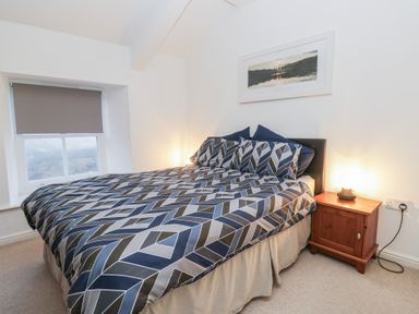 A bedroom with a bed and bedside table at Newlands Fell House near Keswick