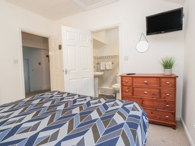 A bedroom with a bed and dresser at Newlands Fell House in Newlands near Keswick