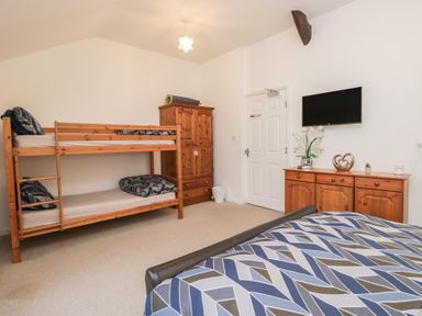 A bedroom with a bunk bed and double bed at Newlands Fell House near Keswick