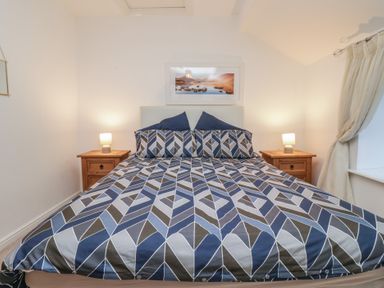 A bedroom with a double bed and lamps at Newlands Fell House in Newlands near Keswick