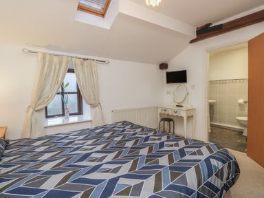 A bedroom with a double bed and a dressing table at Newlands Fell House in Newlands near Keswick