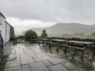 An outdoor area with benches and tables at Newlands Fell House in Newlands near Keswick