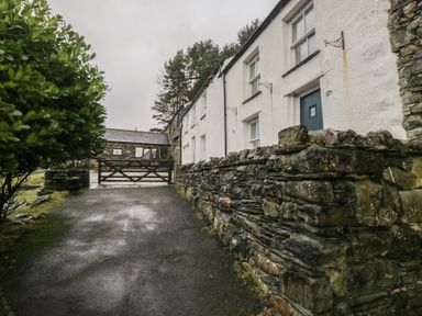 A house with a stone wall and gate at Newlands Fell House in Newlands near Keswick