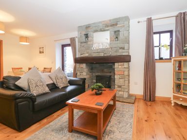 A living room with a fireplace and a coffee table at Newlands Cottage in Keswick
