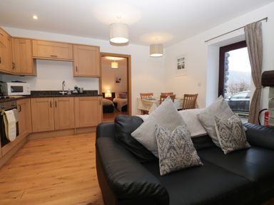 A kitchen with a sofa and dining area at Newlands Cottage in Keswick