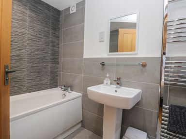 A bathroom with a bathtub and sink at Newlands Cottage in Keswick