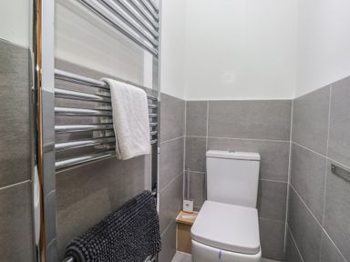 A bathroom with a toilet and towel rail at Newlands Cottage in Keswick