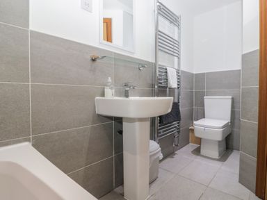 A bathroom with a sink, toilet, and towel rail at Newlands Cottage in Keswick