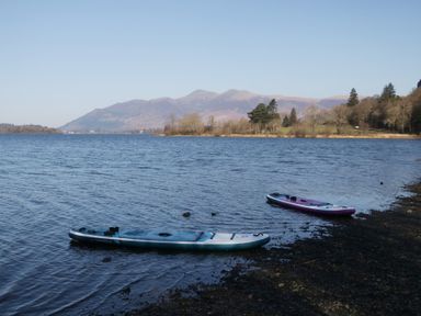 Two kayaks on a lake with mountains in the background at Newlands Cottage in Keswick