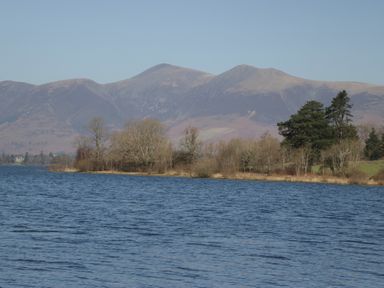 A view of a lake with mountains and trees at Newlands Cottage in Keswick