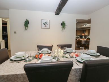A dining table set with plates and glasses at Birkbank Farm Cockermouth