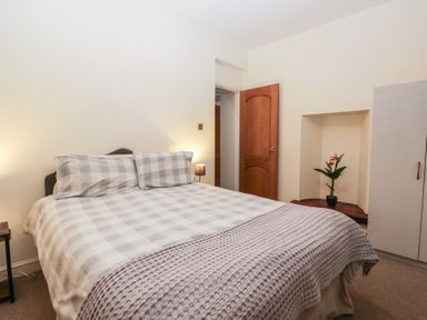 A bedroom with a bed and a plant at Birkbank Farm in Cockermouth