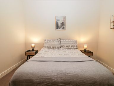 A bedroom with a bed and nightstands at Birkbank Farm in Cockermouth