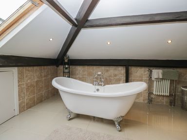 A bathroom with a bathtub and radiator at Birkbank Farm in Cockermouth