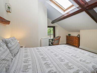 A bedroom with a bed and window at Birkbank Farm in Cockermouth