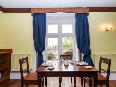 A dining room with a table set for meals at Dowrich West Wing Apartment in Crediton