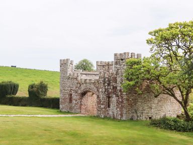A stone castle structure in a grassy area at Dowrich West Wing Apartment in Crediton