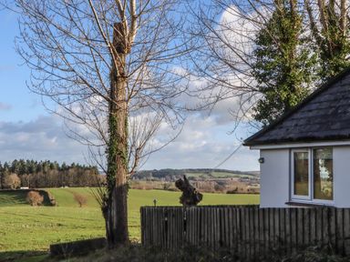 A view of a tree and house near a field at The Old Telephone Exchange Exeter