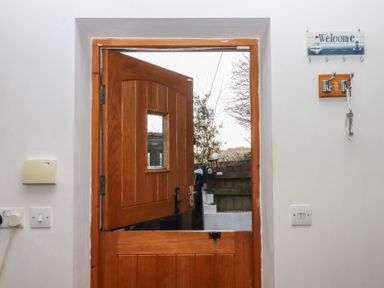 An entrance with a wooden door and welcome sign at The Old Telephone Exchange in Exeter