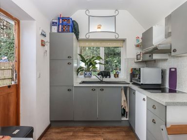 A kitchen with cabinets and a door at The Old Telephone Exchange in Exeter
