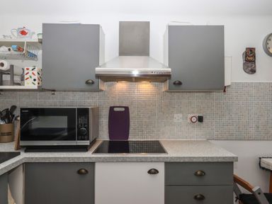 A kitchen with a microwave and cooktop at The Old Telephone Exchange in Exeter