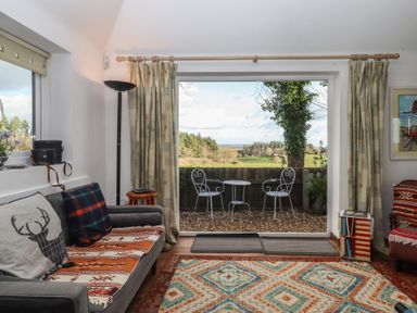 A living room with a view of outdoor chairs and table at The Old Telephone Exchange in Exeter