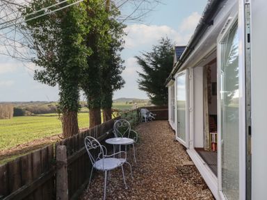 An outdoor area with chairs and tables overlooking countryside at The Old Telephone Exchange in Exeter