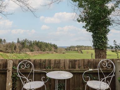 A table and chairs on a patio overlooking a field at The Old Telephone Exchange in Exeter