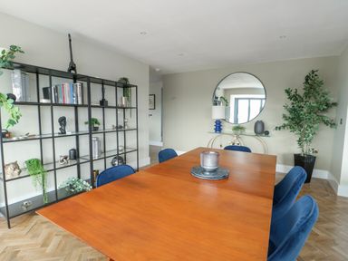 A dining room with a table and chairs at Pengarnedd Amlwch