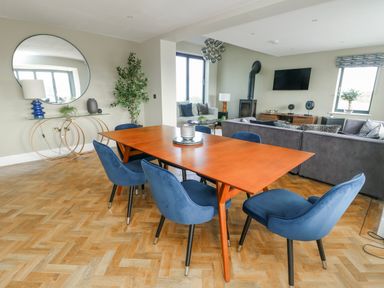 A dining room with a table and chairs at Pengarnedd Amlwch