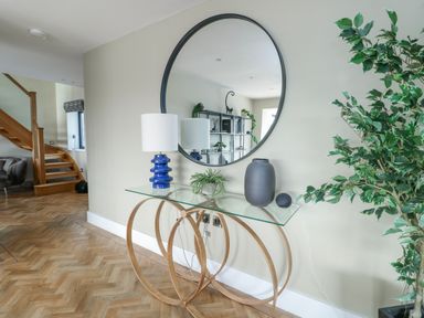 An entrance hall with a console table and a mirror at Pengarnedd in Amlwch