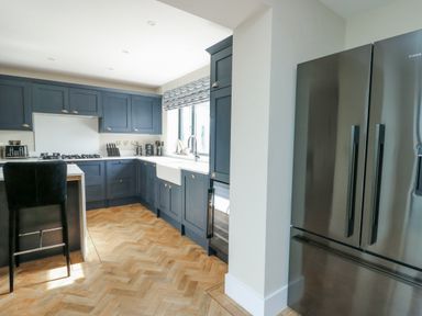 A kitchen with dark cabinets and stainless steel appliances at Pengarnedd in Amlwch