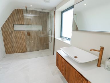 A bathroom with a glass shower and a sink at Pengarnedd in Amlwch