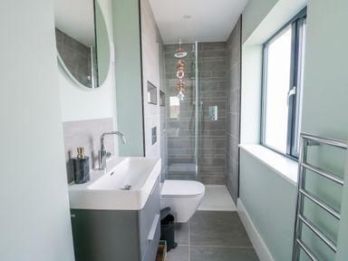A bathroom featuring a sink, shower, and toilet at Pengarnedd in Amlwch