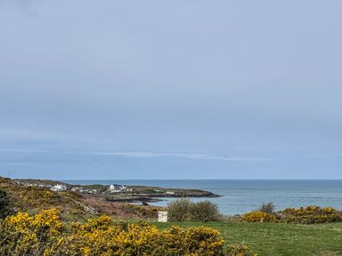 A view of the sea and houses along the coast at Pengarnedd in Amlwch