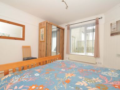 A bedroom with a bed and a mirror at Porthmeor in Wadebridge