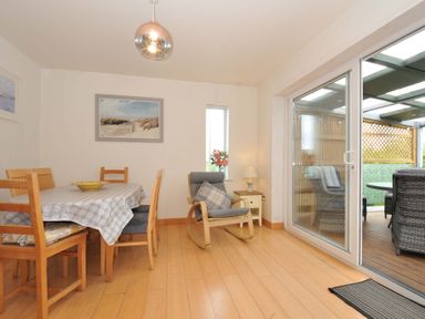 A dining room with a table and chairs at Porthmeor in Wadebridge