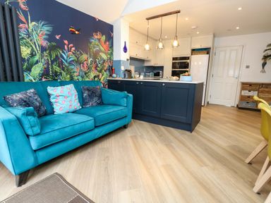 A kitchen with a sofa and kitchen island at Still Waters in Weymouth