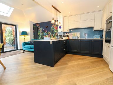 A kitchen with an island and colorful wall decor at Still Waters in Weymouth