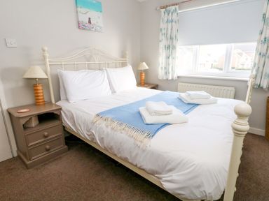 A bedroom with a double bed and nightstand at Still Waters in Weymouth