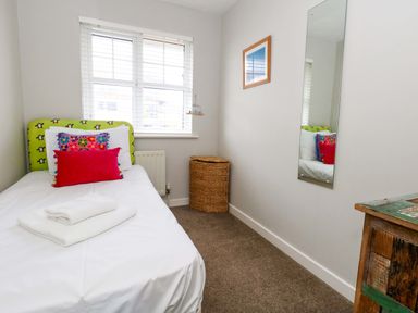 A bedroom with a single bed and mirror at Still Waters in Weymouth